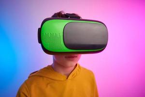 Junge mit virtuell Wirklichkeit Brille auf bunt Hintergrund. Zukunft Technologie foto