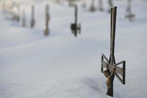 Friedhof Kreuz bedeckt durch Schnee foto