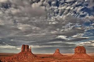 Monument Valley View bei Sonnenuntergang mit wunderbar bewölktem Himmel und Lichtern auf Fäustlingen foto