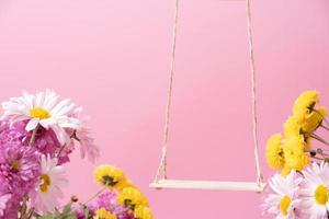 eine Schaukel mit Chrysanthemenblüten als Ständer für Ihr Kosmetikprodukt foto