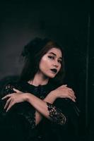 ein asiatisch Teenager hat ein unheimlich Aussehen mit alles schwarz bilden und ein schwarz Kleid mögen ein Hexe Vor Halloween foto