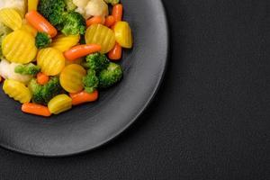 köstlich frisch Gemüse gedämpft Möhren, Brokkoli, Blumenkohl auf ein schwarz Teller foto
