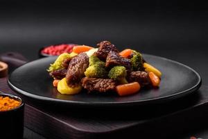 köstlich frisch Rindfleisch und Gemüse Möhren, Brokkoli, Blumenkohl auf ein schwarz Teller foto