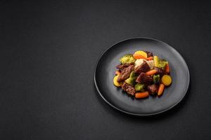 köstlich frisch Rindfleisch und Gemüse Möhren, Brokkoli, Blumenkohl auf ein schwarz Teller foto