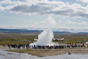 Geysirschlag in Island, während er Wasser bläst foto