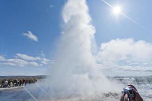 Geysir im Island während weht Wasser foto