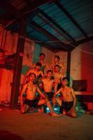 ein Gruppe von Männer ohne Kleider Tanzen posiert im ein alt Gebäude mit ein rot Licht foto