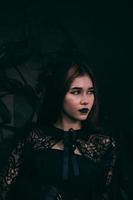 ein asiatisch Teenager hat ein unheimlich Aussehen mit alles schwarz bilden und ein schwarz Kleid mögen ein Hexe Vor Halloween foto