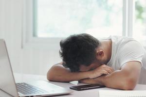 Der Mitarbeiter sitzt gestresst mit seiner Arbeit foto