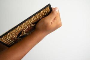 Hand halten ein Koran Buch von Seite Winkel foto