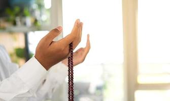 Muslime beten mit Gebet Perlen im ihr Hände foto