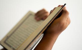 Hände halten und lesen das Koran Buch foto