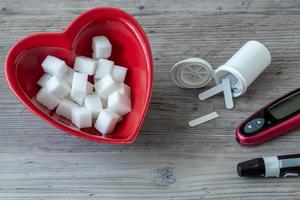 Herz geformt Schüssel und Zucker Würfel. Diabetes testen foto