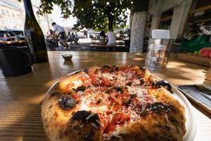 kleine Pizza auf einem Tisch in einem Straßencafé foto