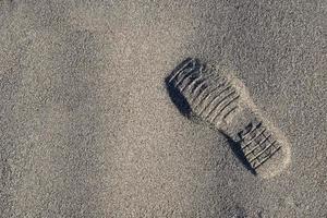 ein Schuhabdruck auf dem Strandsand foto