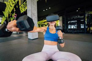 Frau mit Brille der virtuellen Realität, die mit Hanteln trainiert foto