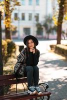 junge Frau auf einer Bank im Herbstpark foto