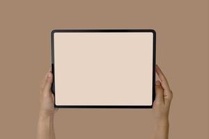 Modellbild der Hände, die ein leeres mobiles Tablett des weißen Bildschirms lokalisiert halten foto