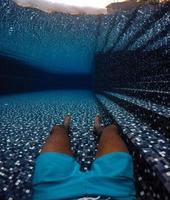 Mann unter Wasser in einem Pool foto
