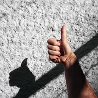 Hand auf das Weiß Mauer spielen mit das Schatten foto