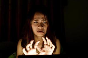 asiatisch Frauen leiden von Überanstrengung der Augen von suchen beim Computers im niedrig Licht. Uhr Filme online foto