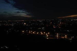 dunkel Blau Wolke mit Weiß Licht Sonnenuntergang Himmel Hintergrund und Stadt Licht Mitternacht Abend Zeit foto