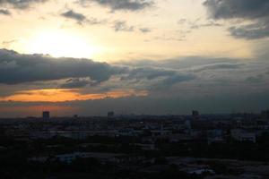 dunkel Blau Wolke mit Weiß Licht Sonne einstellen Himmel Hintergrund und Stadt Licht Mitternacht Abend Zeit foto