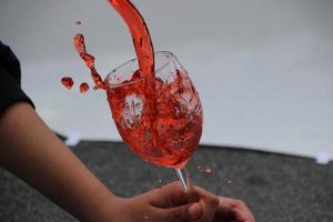 rot Wein Wasser füllen im Wein Glas foto