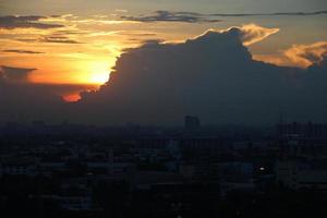 dunkel Blau Wolke mit Weiß Licht Sonne einstellen Himmel Hintergrund und Stadt Licht Mitternacht Abend Zeit foto