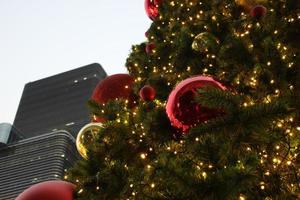 Grün Kiefer Weihnachten Baum mit Licht funkeln und rot Gold Dekoration und Himmel Hintergrund foto