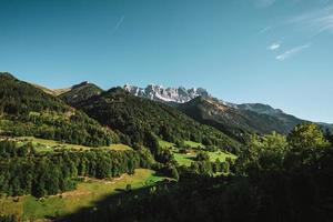 majestätisch Berge im das Alpen bedeckt mit Bäume und Wolken foto