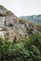 majestätisch Berge im das Alpen bedeckt mit Bäume und Wolken foto