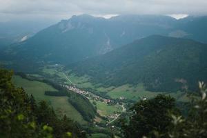 majestätisch Berge im das Alpen bedeckt mit Bäume und Wolken foto