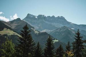 majestätisch Berge im das Alpen bedeckt mit Bäume und Wolken foto