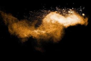abstrakte orange Pulverexplosion auf schwarzem Hintergrund. bewegung des orangefarbenen pulverspritzers einfrieren. foto