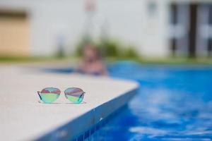 Sonnenbrille durch das Schwimmbad foto