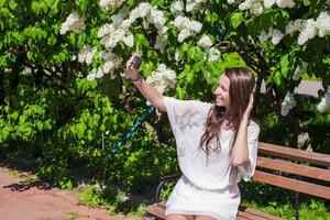 Frau nehmen Telefone auf das Park foto