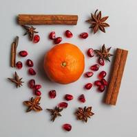 einstellen von saisonal Früchte und Gewürze zum Winter Getränke und Lebensmittel. Zimt Stöcke, Star Anis, Granatapfel Samen, Mandarin, Blaubeere. Hintergrund von Gewürze zum überlegte Wein. foto