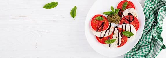 traditionell Italienisch Caprese Salat mit Mozzarella, Tomate, Basilikum und Balsamico Essig. Banner. oben Sicht, Overhead foto