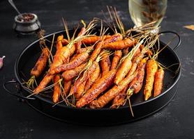 gebackene Bio-Karotten mit Thymian, Honig und Zitrone. Bio veganes Essen. foto