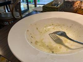 schmutzig Teller mit Essen Reste auf hölzern Hintergrund, oben Aussicht foto