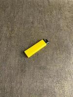 Gelb Feuerzeug isoliert auf Weiß Hintergrund. Hand versucht zu zündete Gelb Feuerzeug. Kopieren Raum. ausgewählt Fokus foto