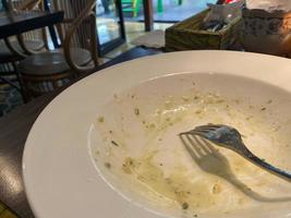 schmutzig Teller mit Essen Reste auf hölzern Hintergrund, oben Aussicht foto