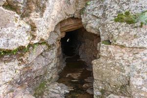 Höhle im felsig Berg mit Fluss auf das Fußboden foto