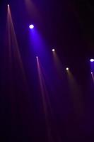 lila Balken von Licht von Bühne Scheinwerfer auf ein dunkel Hintergrund.