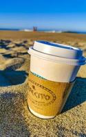 puerto escondido Oaxaca Mexiko 2023 Kaffee zu gehen Becher auf das Strand Sand Meer Wellen. foto