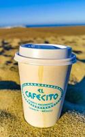 puerto escondido Oaxaca Mexiko 2023 Kaffee zu gehen Becher auf das Strand Sand Meer Wellen. foto