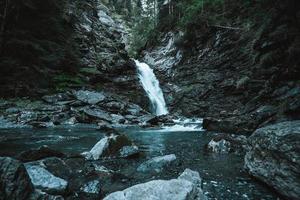 majestätisch Wasserfall umgeben durch Bäume im das Alpen foto