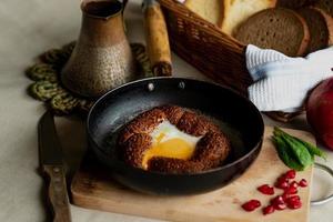 Türkisch Frühstück, durcheinander Eier im ein simit Brötchen im ein braten Pfanne, Kaffee im ein Türke, frisch Brot foto