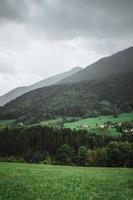 majestätisch Berge im das Alpen bedeckt mit Bäume und Wolken foto